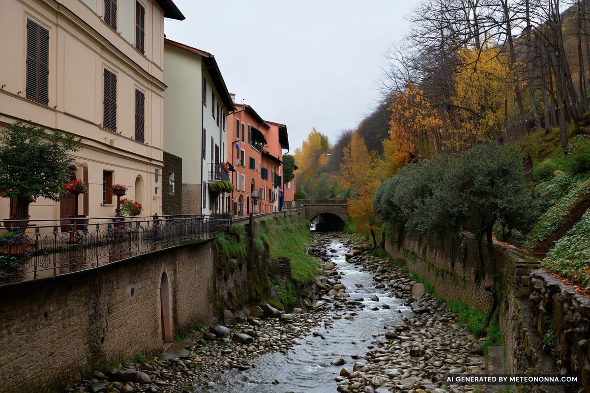 Un canale di torrente in pietra che attraversa le case di un paese del Salernitano, con versanti ripidi e boscosi sullo sfondo